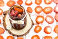 Jar of jam with pieces of fruit, made with organic and natural strawberry. Blurred sliced Ã¢â¬â¹Ã¢â¬â¹strawberries in the background